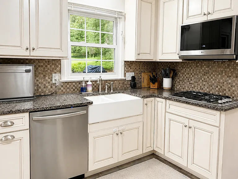 Kitchen with window looking out to patio and backyard