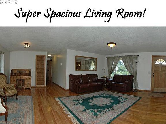 The LARGE living room features beautiful hardwoods, fresh paint, solid-wood panel doors and hardwood