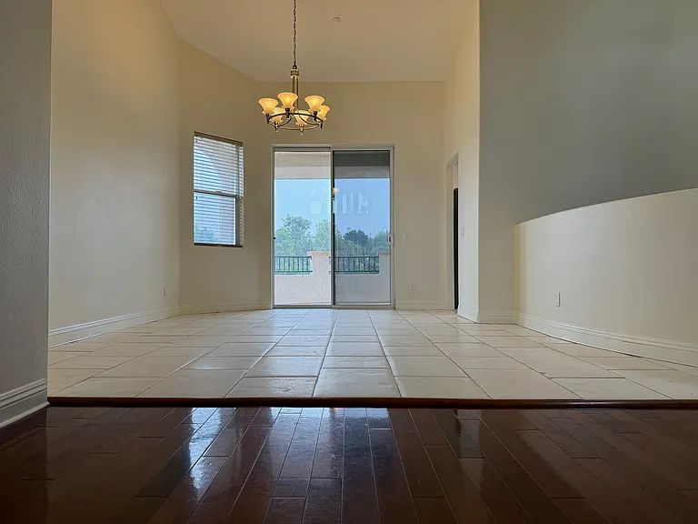 Dining Room with Cathedral Ceilings and Balcony access- limestone floors
