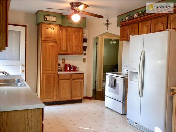 KITCHEN with newer cabinets, pantry, SS sink with newer faucet. Ceiling fan. Window for plants. Stove and refrigerator stay.