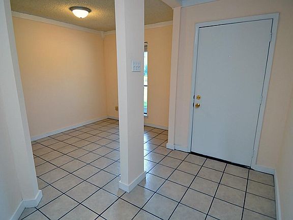 Entry to the home there are nicely tiled floors and architectural beams with entry to the formal living room.