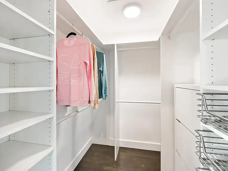 Step into luxury with our expansive walk-in closet, featuring ample storage space.