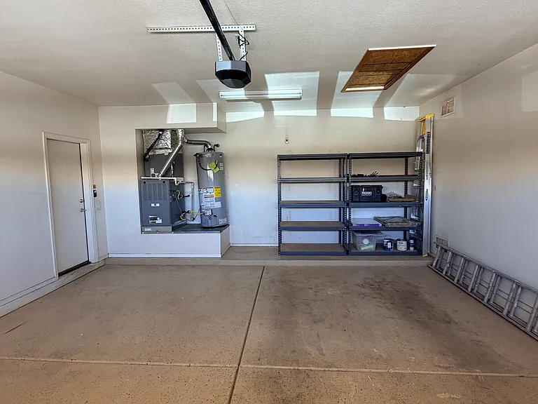 attached two-car garage with shelving and wall-mounted tool organizer