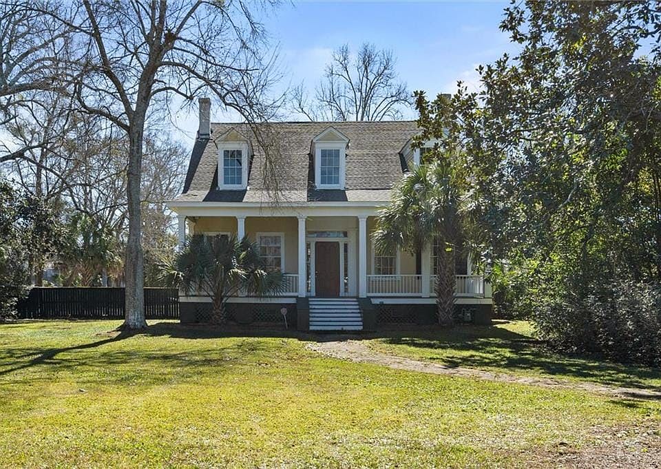 Cape cod home with a front lawn and a porch