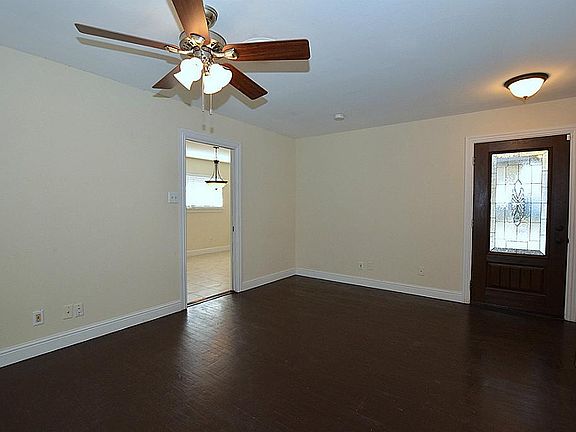 There is a ceiling fan in the den and in all of the bedrooms. The doorway on the left leads into the