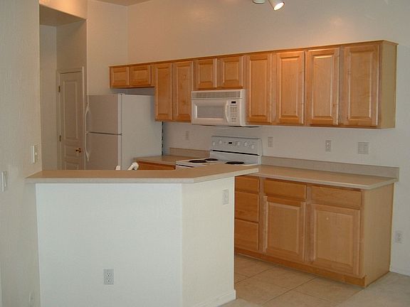 Kitchen open to Dining Room and Rear Patio.