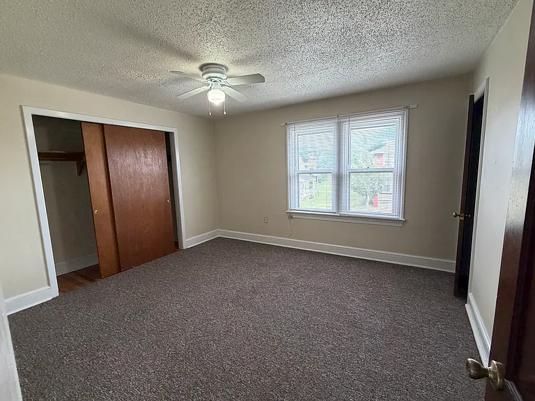 Street front bedroom is 14'X13' and features wall-length sliding door closet, secondary closet and new ceiling fan.
