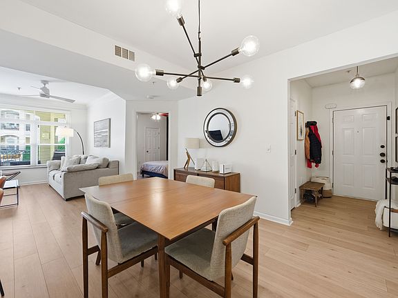 Open, light-filled living room with oak-style flooring and large windows.