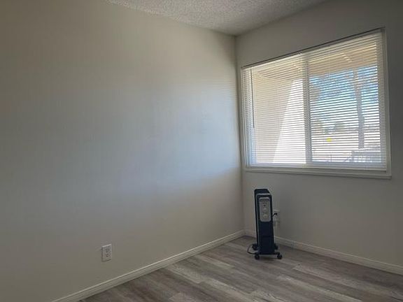 Bedroom with new LVP flooring, new blinds, and an efficient room heater.