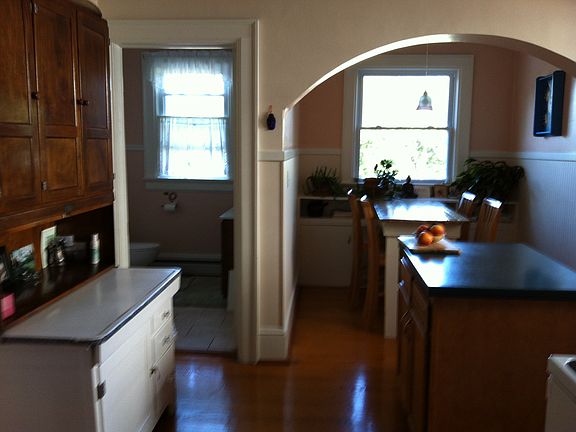 The kitchen with a few extra pieces of furniture. The center island and dining table and chairs remain.