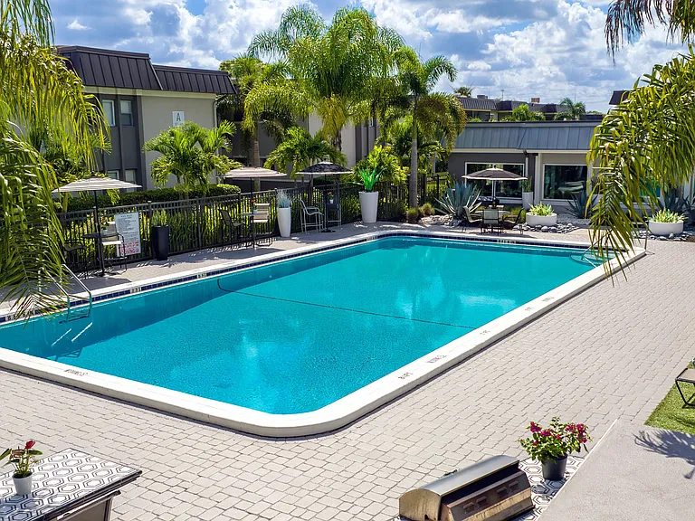 Soak up the sun at the resort-style pool surrounded by lush tropical landscaping, comfortable lounge seating, and shaded areas offering the perfect spot to relax and unwind.