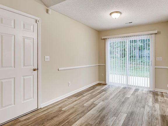Prior pic of dining area with sliding door leading out to back patio. Popcorn ceiling has since been removed. Door to garage on left.