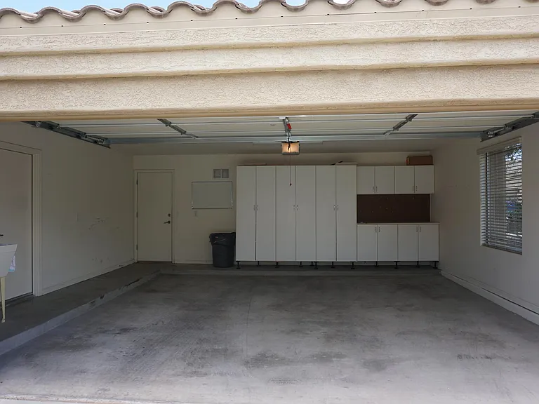 2 Car Garage: Utility cabinets, work station, rear door to the side yard.