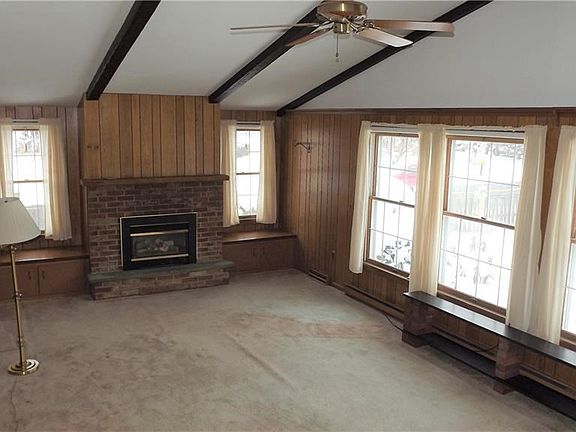 Large family room overlooking rear yard with gas fireplace and a wall of windows.