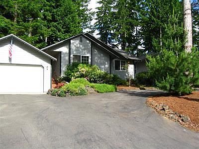 Nestled in trees, lovely home features convenient circle driveway.