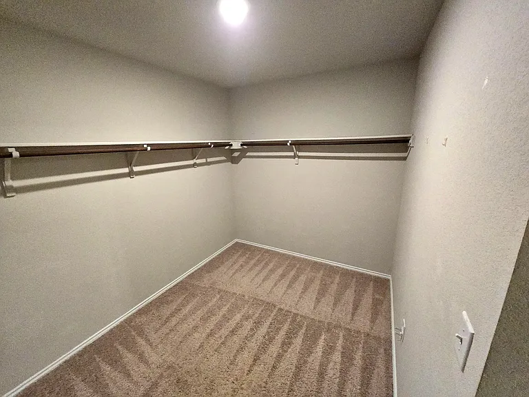 Spacious walk-in closet in primary bedroom and bathroom.
