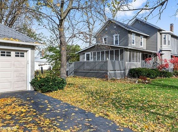 Exterior of home with deck, screened porch and 2 car garage.