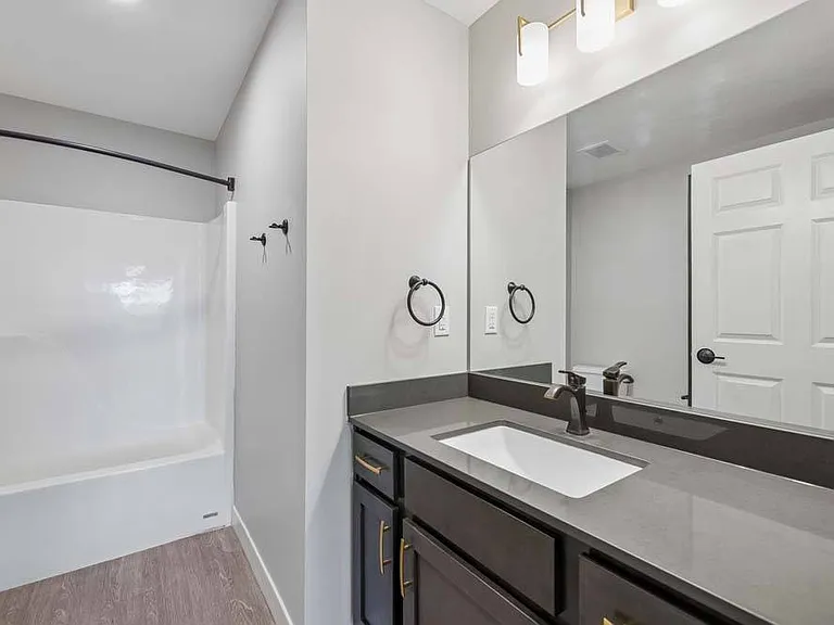 A beautifully appointed bathroom pairs modern finishes with a spacious vanity and a relaxing soaking tub.