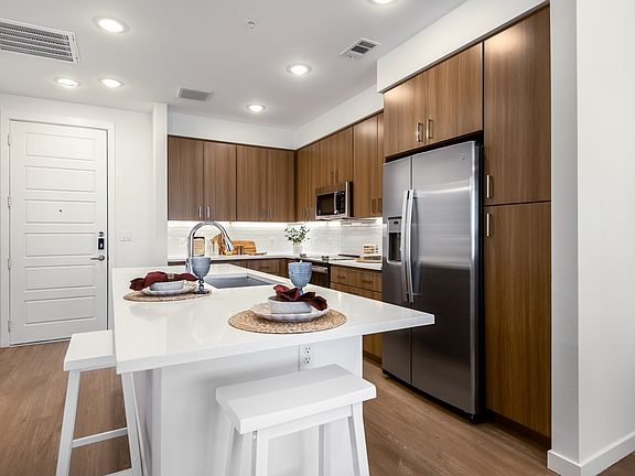 Contemporary Kitchen Featuring White Quartz Island and Wood Cabinetry