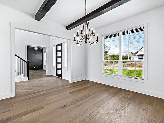 Open formal dining room with windows and a chandelier.