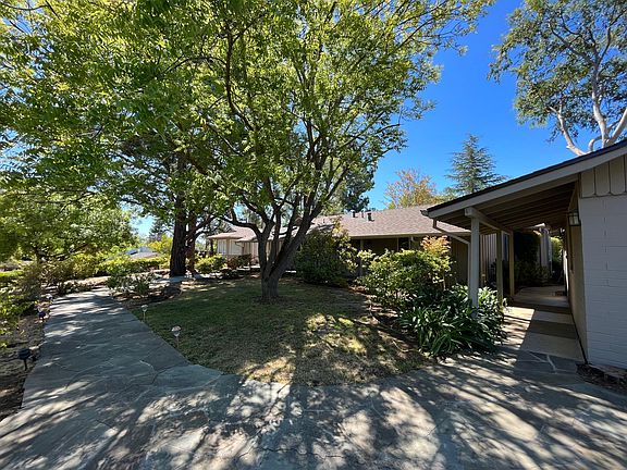 The tranquil stroll through the garden path and the covered walkway welcome you to this comfortable sun-filled home