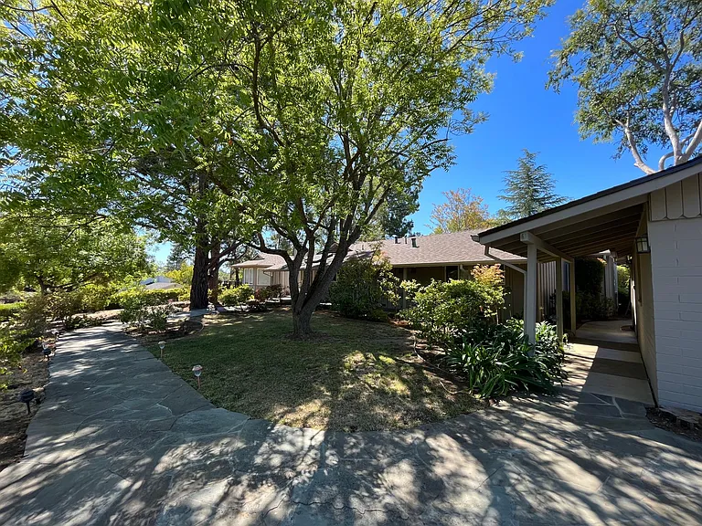 The tranquil stroll through the garden path and the covered walkway welcome you to this comfortable sun-filled home