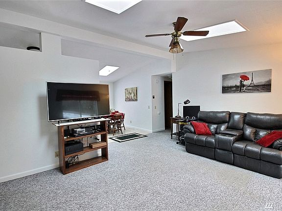 The sizable living room boasts a ceiling fan, updated molding and two skylights.  