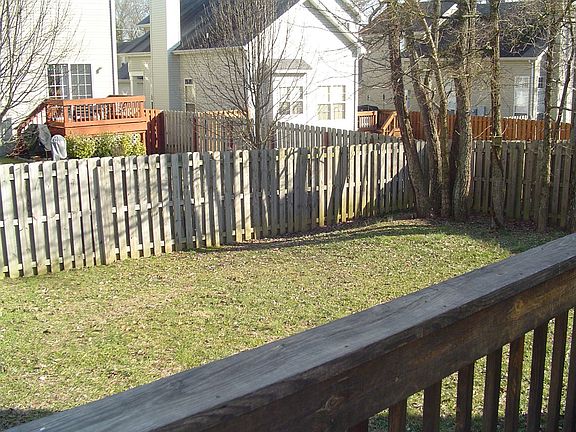 This back yard is fenced and has a huge deck.