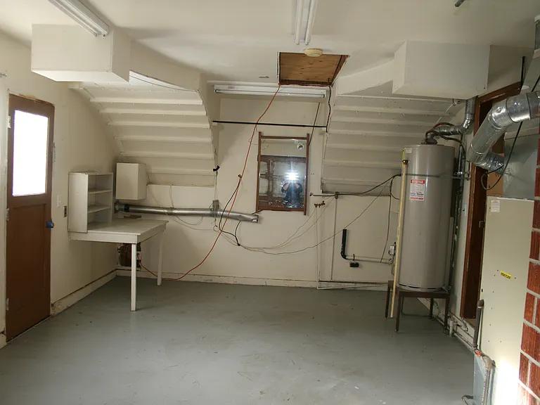 The single car garage has a washer and dryer hook up, a gas furnace for heat, a gas water heater, work bench for projects, and a door to outside.