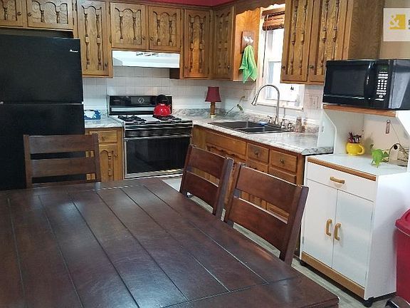 Fully equipped kitchen with new counter top, sink and faucet.  Sliding glass doors lead to covered patio. Doors have built in bl