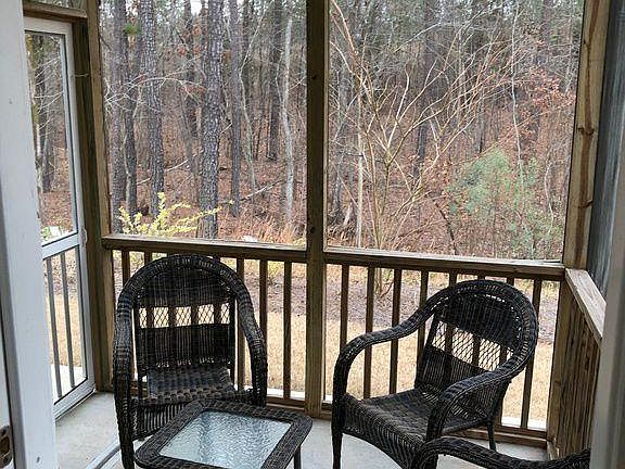 Screened patio backed by woods.