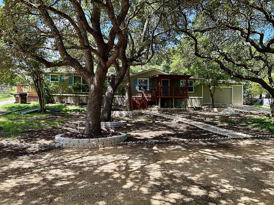 Front view with parking, path and beautiful oak trees, garage on right