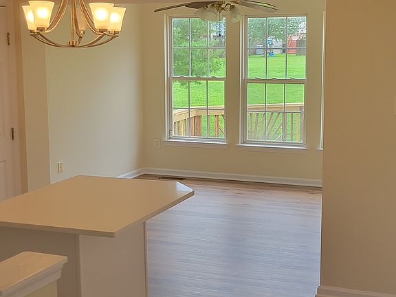 Kitchen leading to the Sunroom with view of Back Yard and Open Space