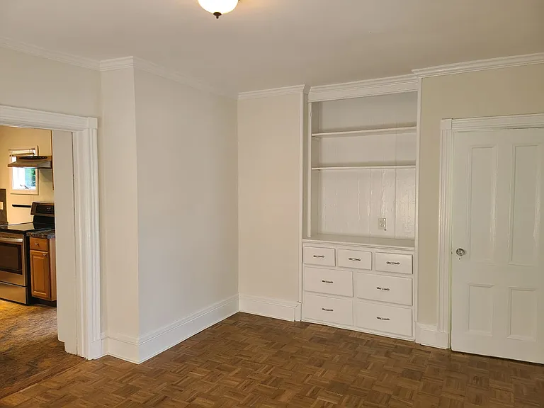 Living room with antique built-in cabinetry and bookshelf.