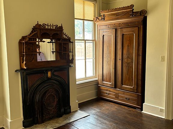 Bedroom with original floor, Victorian walnut armoire storage.