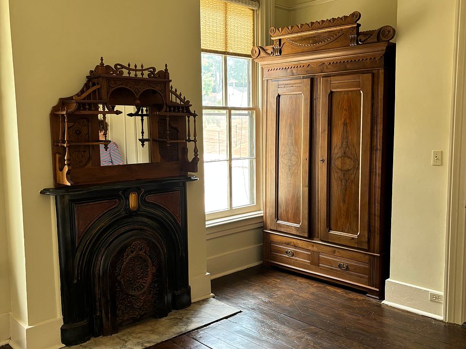 Bedroom with original floor, Victorian walnut armoire storage.