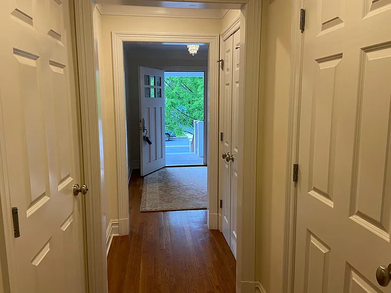 Hallway leading to family room. Doors lead to coat closet, powder room and stairs to garage.