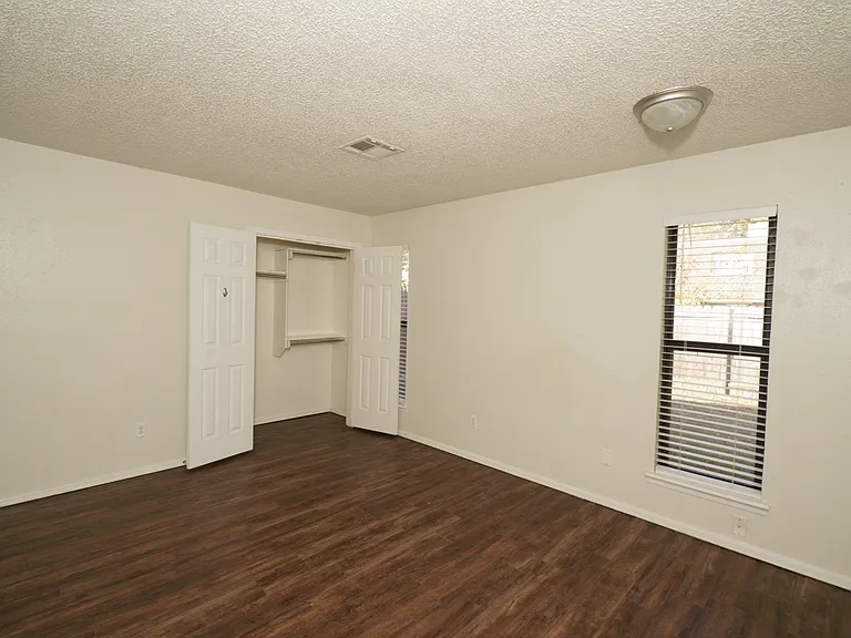 Bedroom 1: Large room with updated flooring and ample closet space.
