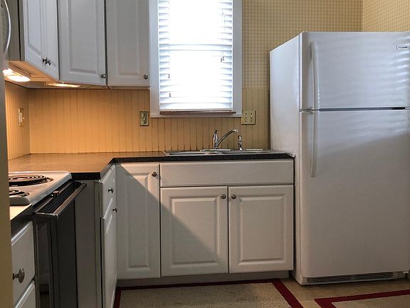 Kitchen with ample cupboard space. Refrigerator, stove/oven, microwave, and garbage disposal are included.