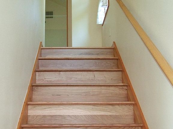 Stairs leading to two bedrooms, bathroom, and washer-dryer cubicle upstairs.
