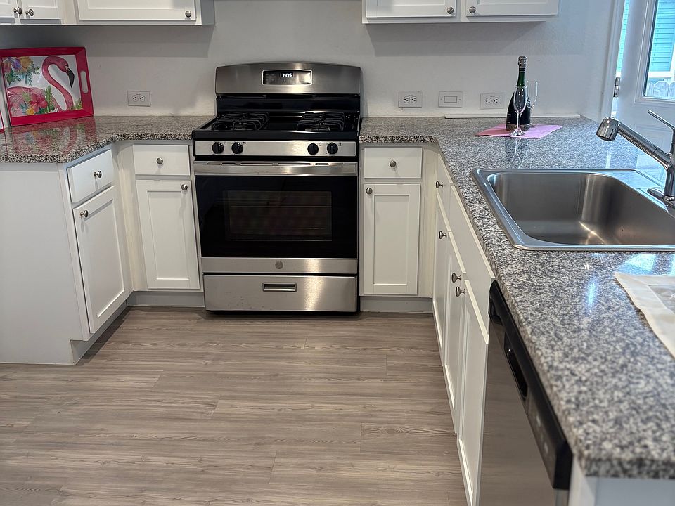 Stainless steel appliances and granite counter tops with white cabinets in kitchen. All appliances provided.