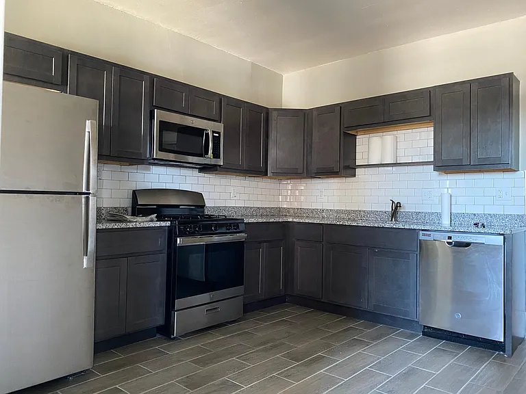 Kitchen with new tile, cabinets, granite counters, and stainless appliances. Room for additional small breakfast table.