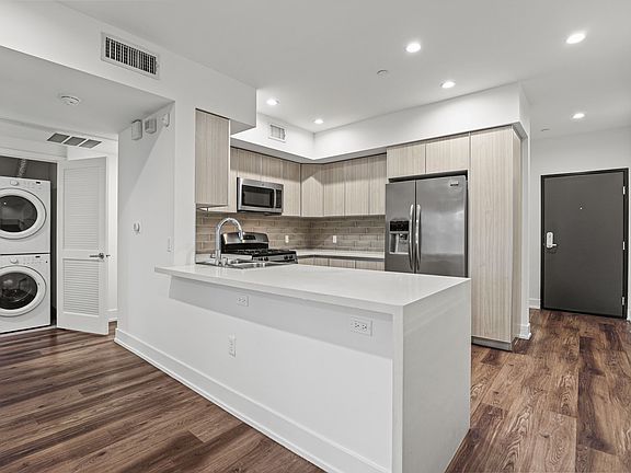 Kitchen with a Countertop Bar and In-Suite Washer & Dryer