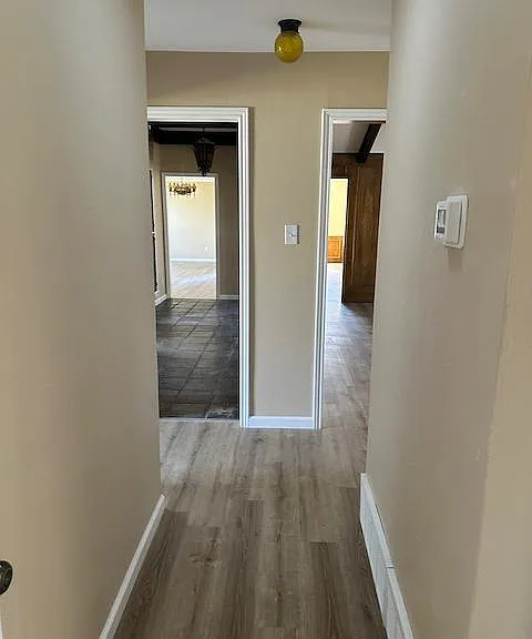 View down hallway includes skylight and newly installed wood flooring.