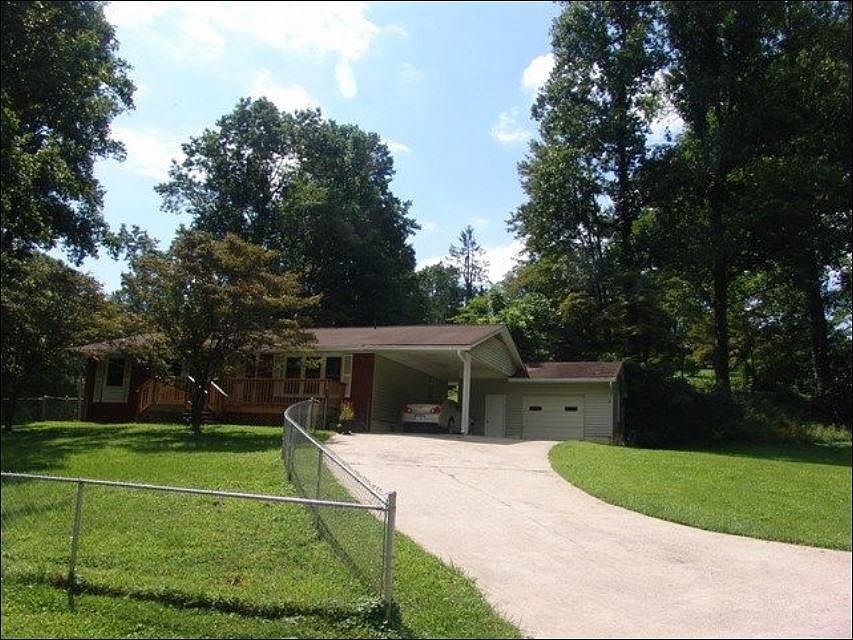 Overview of front and side of house including fenced yard.