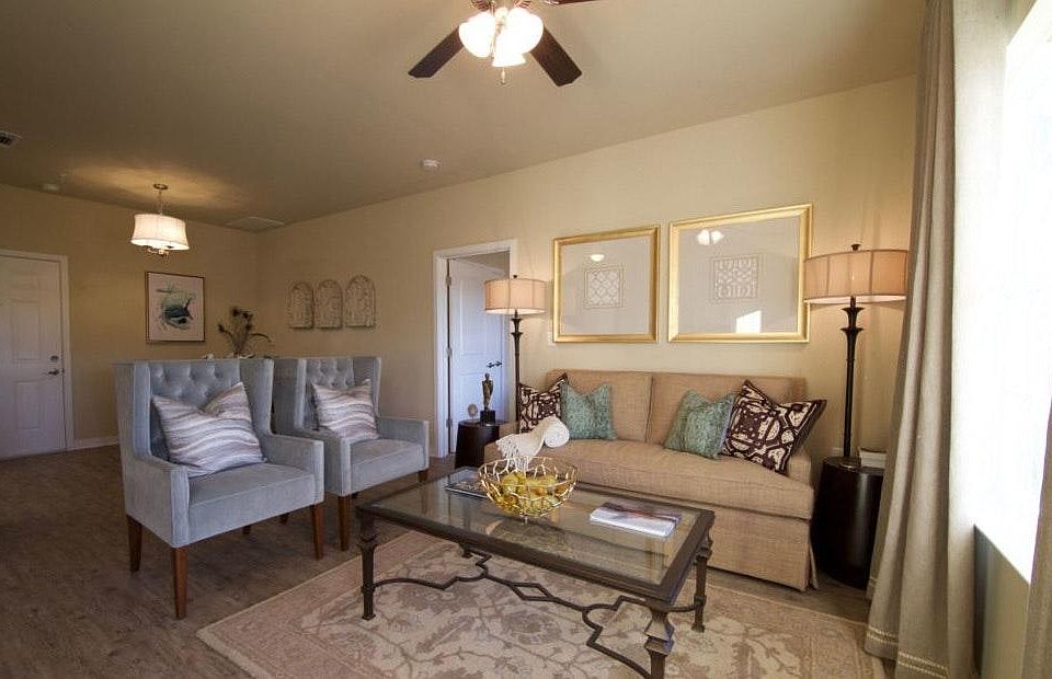 Living room area has wood-look tile floors and ceiling fan i
