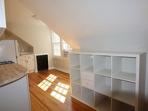 Bright eat in kitchen with natural light from windows overlooking a wooded backyard.