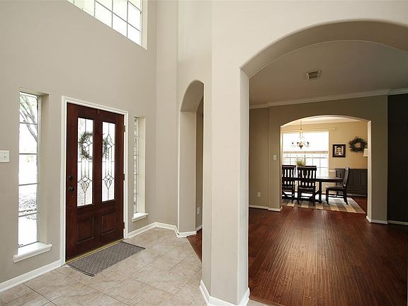 View of front door and formal living area with updated wood floors.
