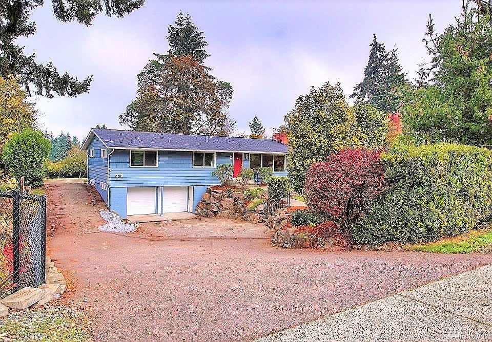 Mature landscaping in the front yard.  Separate entrance to basement next to two car garage.