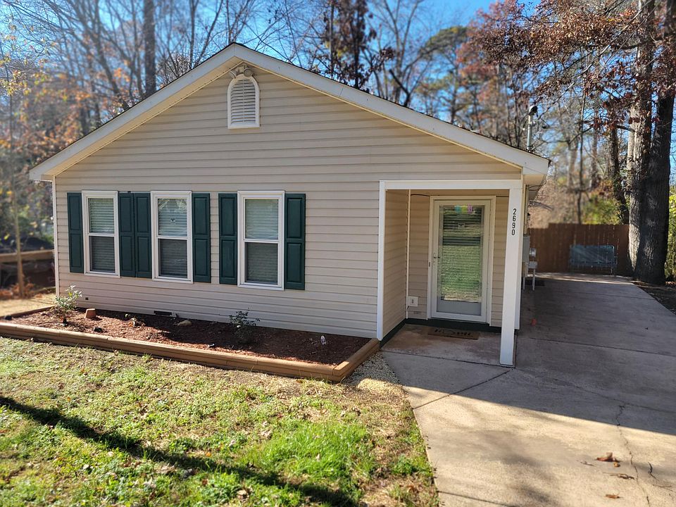 Welcome to 2690 Fairlane Drive, front of house with new flowering bushes and front door